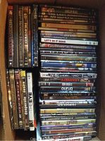 Photo showing a box containing 51 assorted DVD movies with various visible titles and genres.