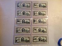 Photo of ten Franklin Mint Statehood Series two dollar bills arranged in two columns, all in protective plastic sleeves.