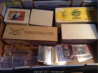 Box of multiple sports cards and card sets including 1987 Baseball Puzzle & Cards and 1991 Upper Deck Baseball 700 Card Set along with loose cards in plastic sleeves.