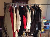Photo showing a spread of 25 jackets and sweaters hung on clothing rack, various styles and colors