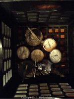 Photo showing a crate containing five oxygen and acetylene pressure gauges with round, needle dial faces and attached valves or adjustment knobs.