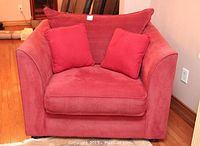 Front view of the red fabric armchair with cushions placed inside seat and backrest.