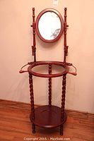 Wooden wash stand with oval mirror, showing entire piece including twisted legs and circular shelf.