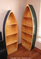 Two boat-shaped bookcases side by side showing full view