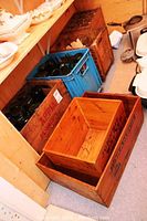 Overview showing five wooden crates and a plastic crate with bottles on floor.