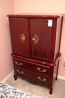 Full view of the vintage wood dresser showing two drawers at the bottom and double-door cabinet at the top with brass handles.