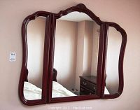 Front view of the tri-fold wall mirror showing three mirror panels and wooden frame with decorative top.