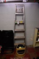 Full view of aluminum folding ladder showing five steps and structural frame.