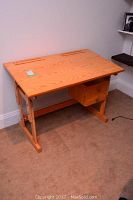 Full front view of the wooden desk with adjustable top and two drawers, showing size and condition.