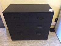 Front view of black IKEA chest showing three drawers and handles.