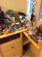 Overview of small decorative items including ceramic, glass, and wooden pieces on yellow shelving.
