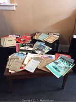Wide view of the collection of various sheet music on a table and a smaller surface.