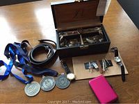 Overview of open jewelry box, medals, belt, card case, watches, cufflinks
