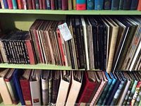 Wide view of shelf with vinyl records organized vertically with some boxed sets and albums