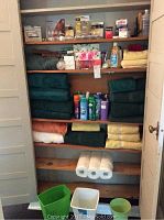 Wide view of shelves filled with towels in various colors and some plastic containers at the bottom.