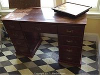 Wide shot of the wood desk showing multiple drawers and an added lap holder on top.