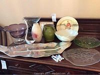 Wide view of silverplate tray, multiple bowls, vases, and Royal Doulton plate on wooden surface