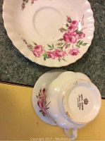 Royal Albert cup and saucer with pink rose floral pattern and silver rim shown from top and base marking