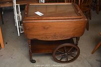 Front view of wooden tea cart with glass-topped removable tray in place