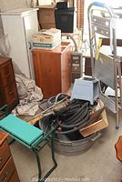 Lot setup showing metal step ladder, gardening stool, tin tub with tools, boxes and furniture.