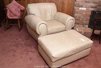 Overall view of beige leather armchair and ottoman set on carpet