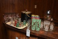 Overview of the entire barware lot showing the shaker, ice bucket, multiple glasses on trays including pastel printed highballs and fish printed glasses.