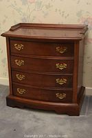 Full front view of Kroehler wood side table showing four drawers and brass handles, ornate base and raised lip top design.