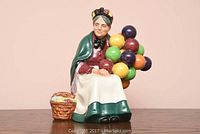 Front view of the Royal Doulton figurine depicting an elderly woman with colorful balloons and basket