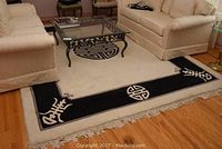 Full view of the rectangular area rug laid out in a living room with sofa and glass coffee table.