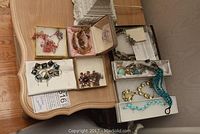 Photo of multiple costume jewelry pieces including bracelets and necklaces displayed on a wooden surface.