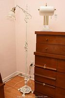 Full view of the vintage floor lamp standing next to a wooden chest, showing overall height and design.
