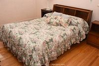 Full view of assembled double bed with floral linens and headboard shelves