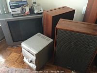 Overview showing CRT TV, Panasonic cordless phone with base, stereo system, and two wooden Yamaha speakers.