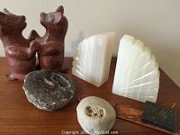 View of all items including ceramic dog figurines, alabaster bookends, geode, leather bookmark, and decorative stone cube.