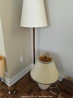 Full view of teak floor lamp with shade and ceramic table lamp on floor