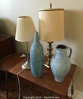 Group shot of two table lamps and two pottery vases on wooden table