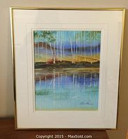 Framed watercolour painting showing birch trees and reflections in water.