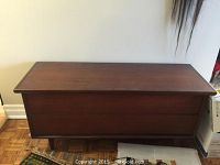 Front exterior view of rectangular teak storage chest with hinged lid