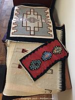 Three wool wall-hangings stacked, showing all three designs and sizes