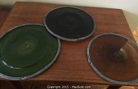 Three stained glass hangings displayed on a wooden surface, showing colors and condition.