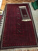 Full view of the large red wool runner rug showing overall pattern and fringed ends