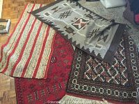 View of all four rugs and wall hanging showing colors, patterns and condition.
