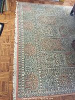 Rug full view on wood floor showing overall pattern and fringe