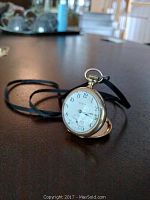 Front view of Elgin pocket watch open to dial, showing white dial with black numerals and small seconds subdial