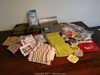 Image showing kitchen linens spread out on table including towels, napkins, coasters, pot holders, and matchboxes.