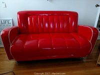 Front view of red retro sofa showing seat and back tufting