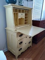 Front view of antique desk with top section open showing cubbyholes and fold-down surface.