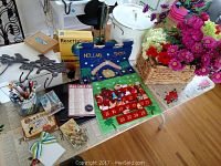 Table top with Rosetta Stone French program box, metal wall hooks, pens, small decorative boxes, ribbon, festive advent calendar decoration, and a file box.