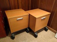 Both file cabinets side by side showing wood finish, single drawer, and caster wheels.