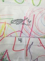 Close-up of the signed portion of the white hockey sock with colorful drawings and player number 4.